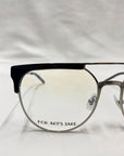 Close-up of Frosty geometric glasses with a metal frame and black detail on the top rim. The words "FOR ART'S SAKE®" are inscribed in black text on the inside of the lens. Featuring jade gemstone nose pads, these eyeglasses are set against a simple, light-colored backdrop.