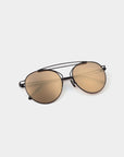 For Art's Sake® T-shirt - Sunglasses feature gold-tinted, UVA & UVB-protected lenses in an aviator style with a slim black stainless steel frame, displayed on a light grey surface.