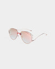 The Dark Eyes sunglasses by For Art's Sake® are stylish pink-tinted aviators with 100% UV protection and rose gold stainless steel frames, featuring thin metal arms and nose pads, displayed on a white background.