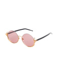 The Ariel sunglasses by For Art's Sake® feature round gold metal frames, black arms, and pink-tinted lenses—fashion-forward eyewear for a standout look, displayed on a white background.