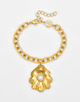 The Shell Pendant Bracelet by For Art's Sake® features a gold chain, a large textured gold leaf pendant with a central white pearl, plus a lobster clasp and adjustable extension chain.