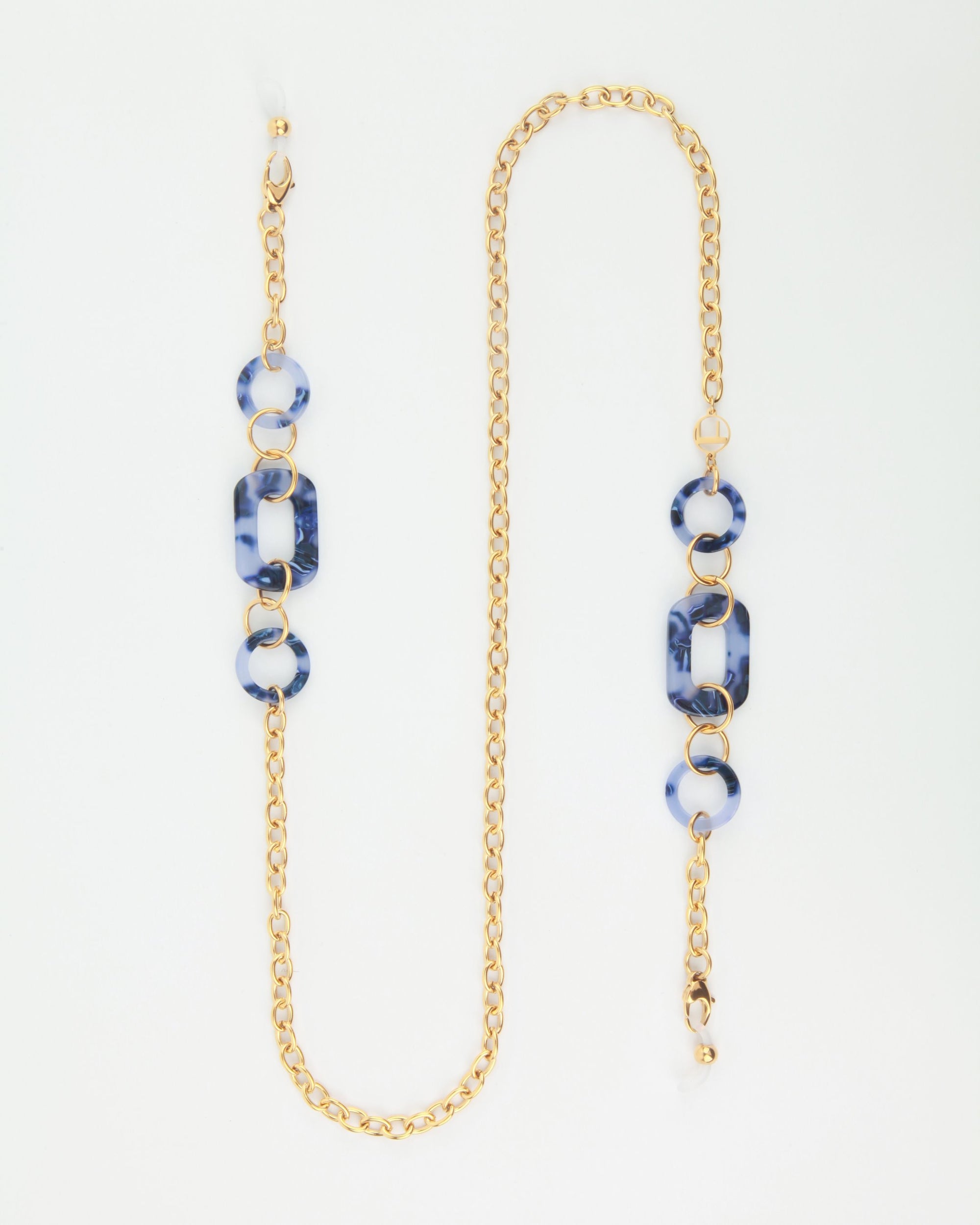 A stylish NYC Glasses Chain composed of an 18-karat gold-plated chain interspersed with blue marbled resin rings and rectangular links by For Art's Sake®. The design alternates between the resin pieces and gold chain, creating a balanced and elegant look against a white background.
