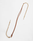 A stylish Soho Glasses Chain featuring a combination of a premium leather cord and 18K gold-plated chain elements by For Art's Sake®. The design includes a knot near the end of the leather cord and decorative beads on both the leather and chain sections.