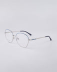 For Art's Sake® Coco: Silver stainless steel frames with rounded rims, thin temples, subtle blue accents on the top frame and tips, and jade nose pads for comfort—all shown on a light gray background.