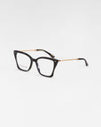 A pair of rectangular Dion eyeglasses with tortoiseshell frames and gold-accented temples featuring intricate chain-like detailing, equipped with a blue light filter, showcased on a plain white background by For Art's Sake®.