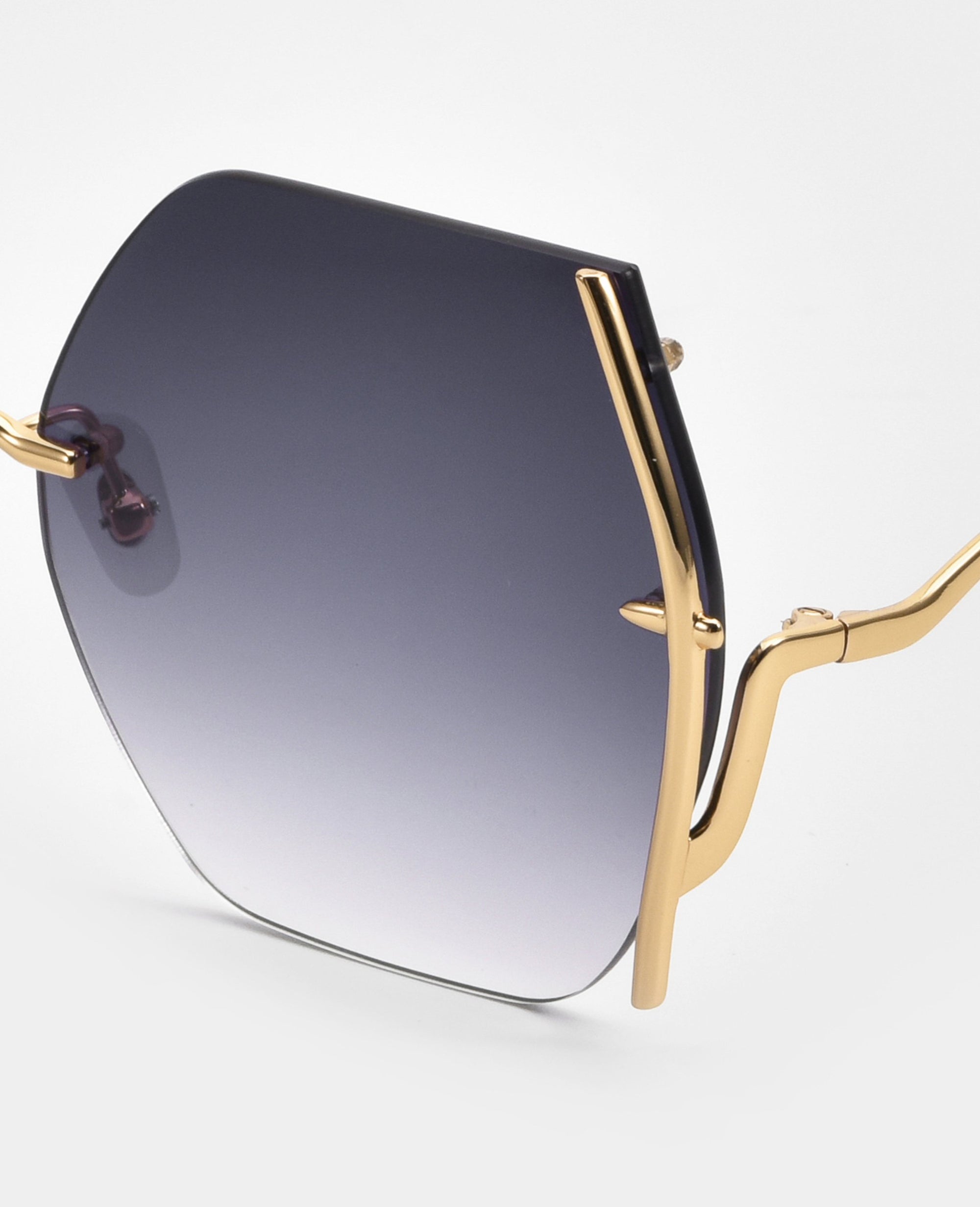 Close-up of For Art's Sake® Generation sunglasses, showcasing hexagonal gradient lenses and a gold geometric frame. Provides UV protection against harmful rays on a plain white background.