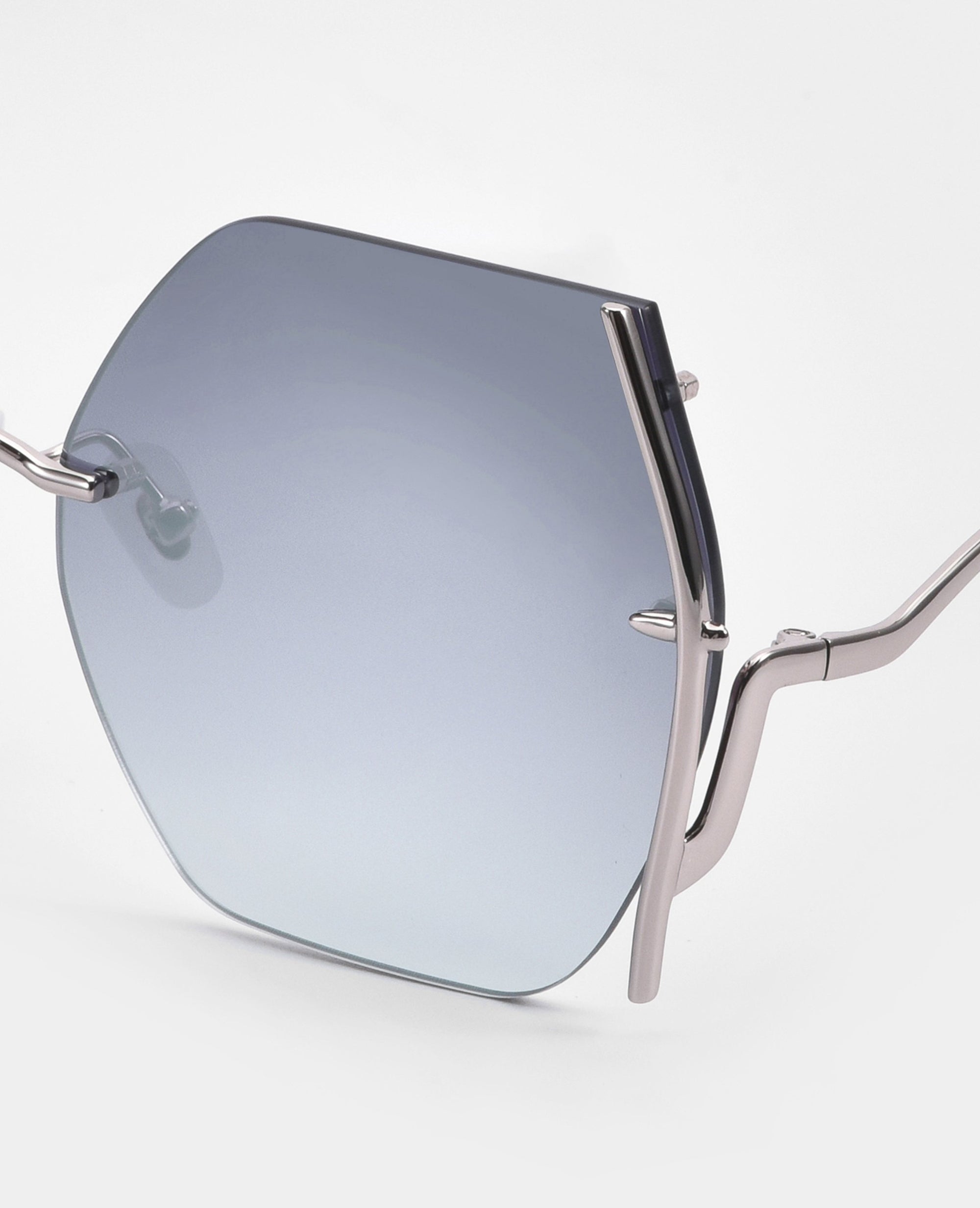 Close-up of the For Art's Sake® Generation sunglasses: a silver metal frame with a single geometric, blue-tinted lens, UV protection, curved arms, and jadestone nosepads displayed against a white background.