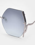 Close-up of the For Art's Sake® Generation sunglasses: a silver metal frame with a single geometric, blue-tinted lens, UV protection, curved arms, and jadestone nosepads displayed against a white background.