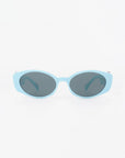 A pair of light blue oval sunglasses with dark tinted, ultra-lightweight nylon lenses offering 100% UVA & UVB protection. The background is plain white, making the For Art's Sake® Frida Portrait sunglasses the focal point of the image.