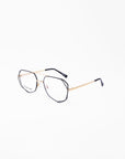 A pair of stylish Genius Two eyeglasses by For Art's Sake® with thin gold metal frames and black temple tips against a plain white background. The hexagonal lenses, equipped with a blue light filter, offer a modern and chic look while providing essential eye protection.