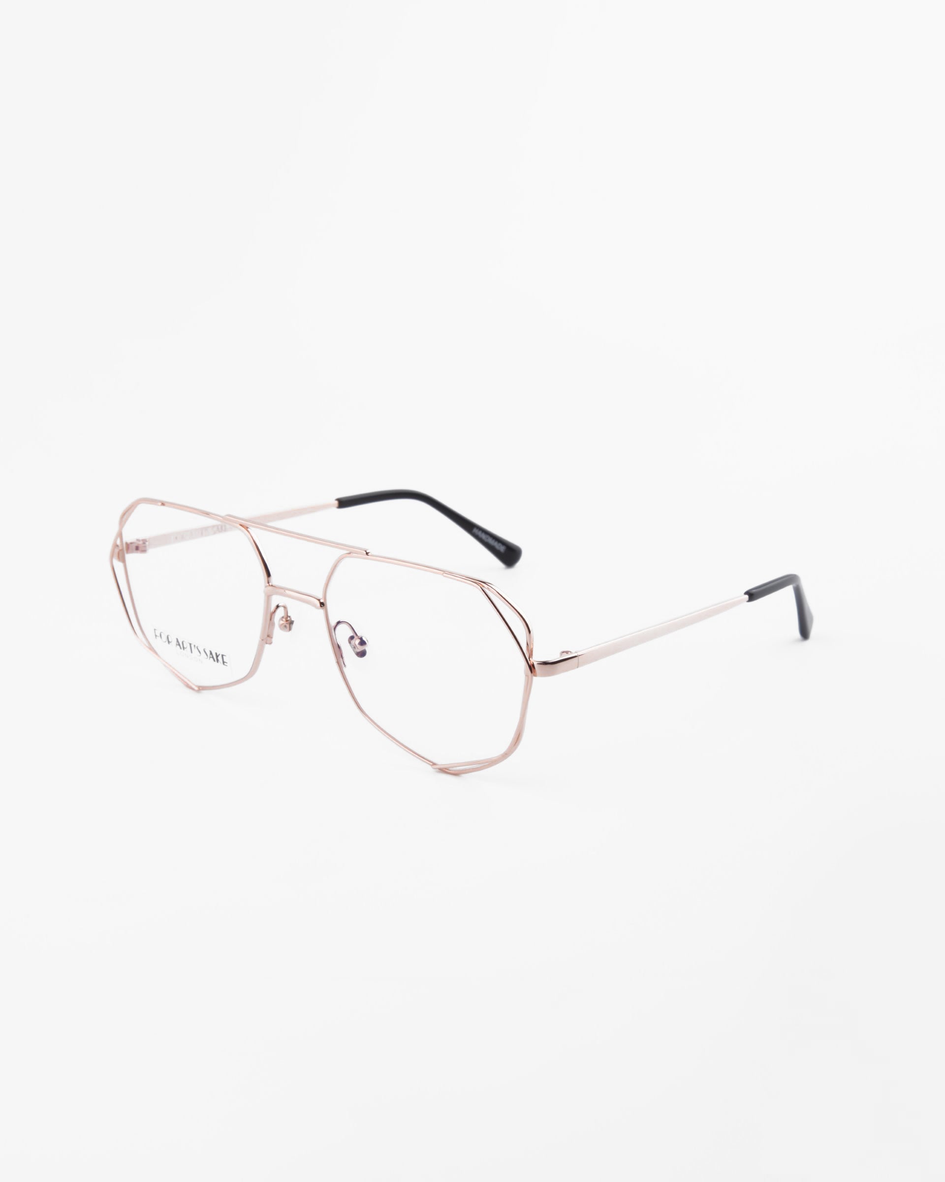 A pair of Genius Two metal-frame eyeglasses by For Art's Sake® with clear lenses featuring blue light filter technology. The frames are thin and gold-colored with black temple tips. The eyeglasses are photographed at a three-quarter angle on a white background.