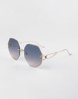 The Hera sunglasses by For Art's Sake® feature oversized octagonal gold frames, adjustable nosepads, and blue gradient UV-protective lenses. Displayed on a white background. (LAST ONE).
