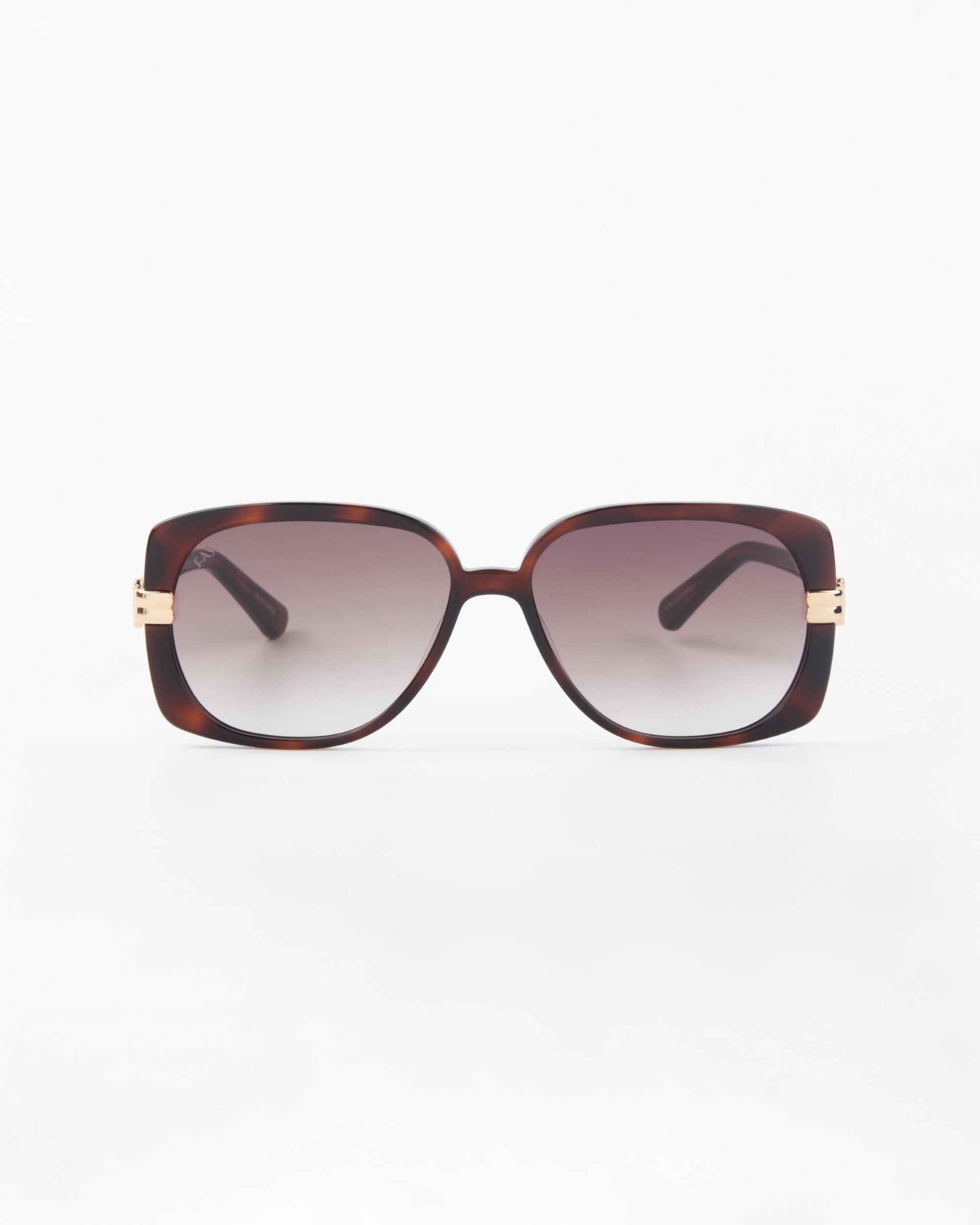 The Icon-ARC shades by For Art's Sake® feature D-frame tortoiseshell frames with dark gradient lenses for UVA/UVB protection. Gold-accented temples near the hinges add style and elegance against a plain white background.