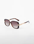 For Art's Sake® presents the Icon- ARC sunglasses, featuring square UVA & UVB-protected lenses with a dark tint. The modern elegance shines through with a dark tortoiseshell frame and gold temple accents, crafted from handmade acetate and displayed on a white background.