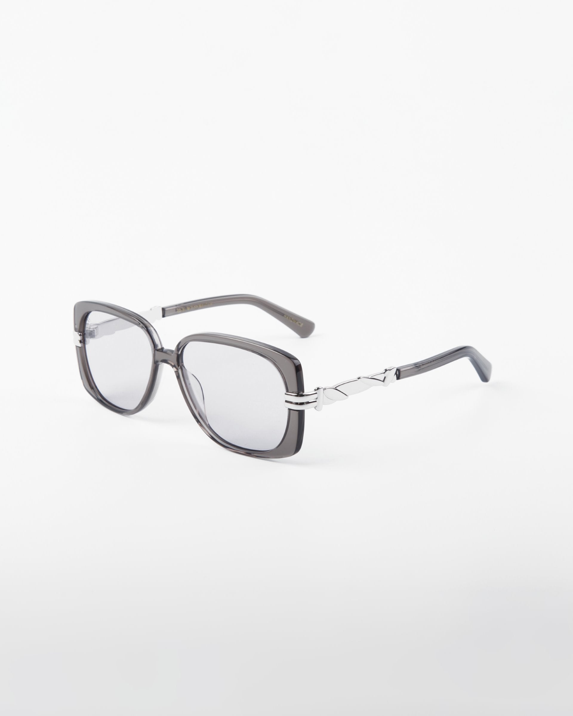 The Icon-ARC sunglasses by For Art's Sake® have square acetate frames with dark lenses and black-silver arms featuring a geometric pattern. They offer UVA & UVB protection and are showcased against a white background.