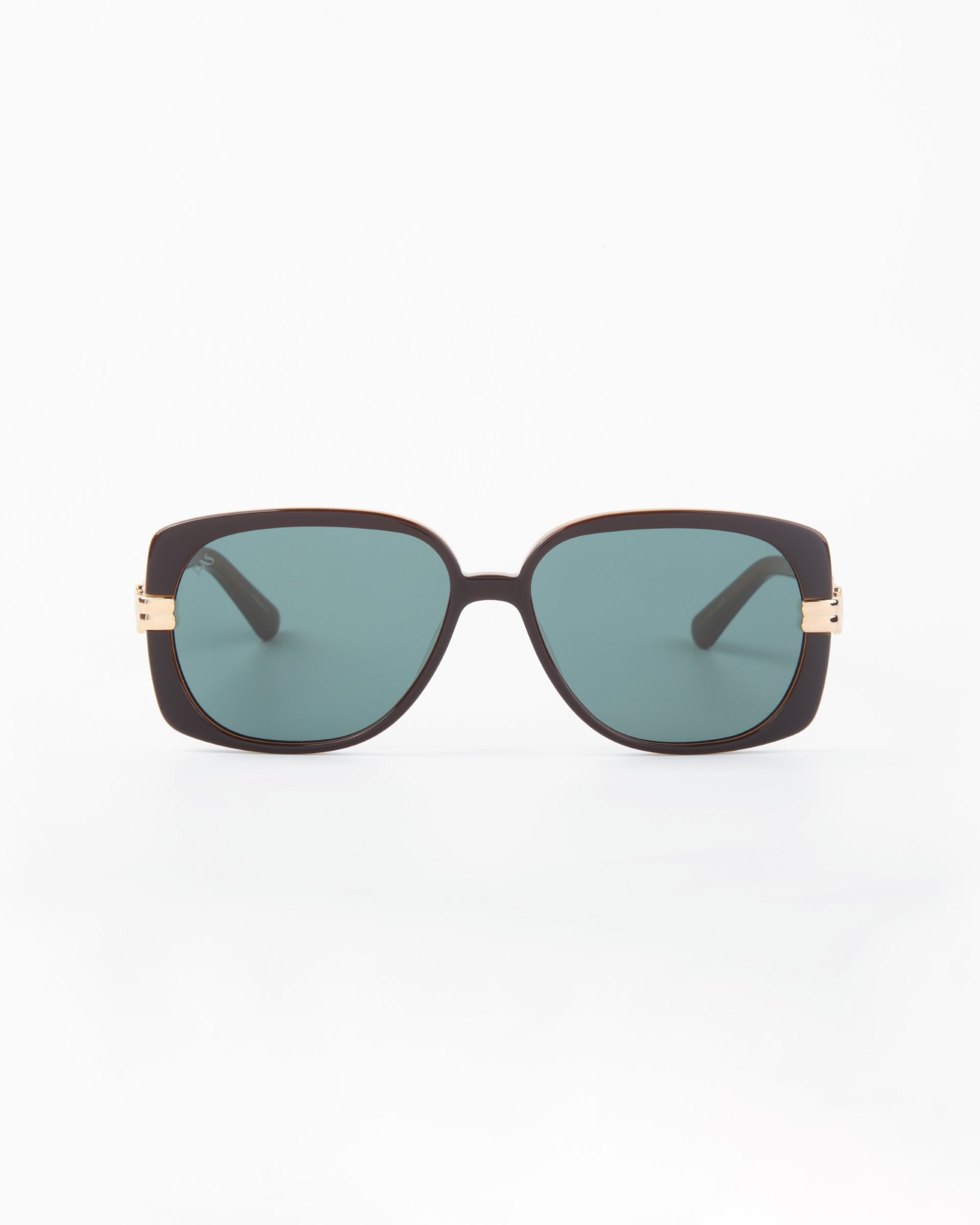 The Icon-ARC sunglasses by For Art's Sake® feature a sleek D-frame with dark frames, teal-tinted lenses, and gold-accented hinges. Crafted from handmade acetate, these shades offer UVA & UVB protection and are elegantly showcased against a plain white background.