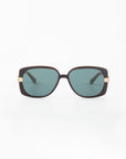 The Icon-ARC sunglasses by For Art's Sake® feature a sleek D-frame with dark frames, teal-tinted lenses, and gold-accented hinges. Crafted from handmade acetate, these shades offer UVA & UVB protection and are elegantly showcased against a plain white background.