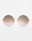A pair of round, gradient-tinted **Love Story** shades from **For Art's Sake®** with thin, rose-gold frames. The temples feature small, heart-shaped decorations near the lenses and jadestone nose pads. The background is plain white, ensuring they stand out while offering 100% UV protection.