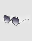 The Wonderland sunglasses by For Art's Sake® feature black, round frames, dark gradient lenses with jadestone nose pads, and provide 100% UV protection—shown on a plain light gray background.