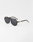 A pair of black General sunglasses with dark nylon lenses and 18-karat gold plated accents on the hinges and bridge. The temples are black with a gold detail near the hinges, and the For Art's Sake® brand name is visible on the side. The background is plain white.
