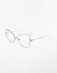 The Lady-S by For Art's Sake® showcases silver cat-eye glasses with clear lenses and thin metal frames against a white backdrop. This eyewear boasts sleek design, curved temples, and intricate twisted metalwork, ideal for those seeking elegance.
