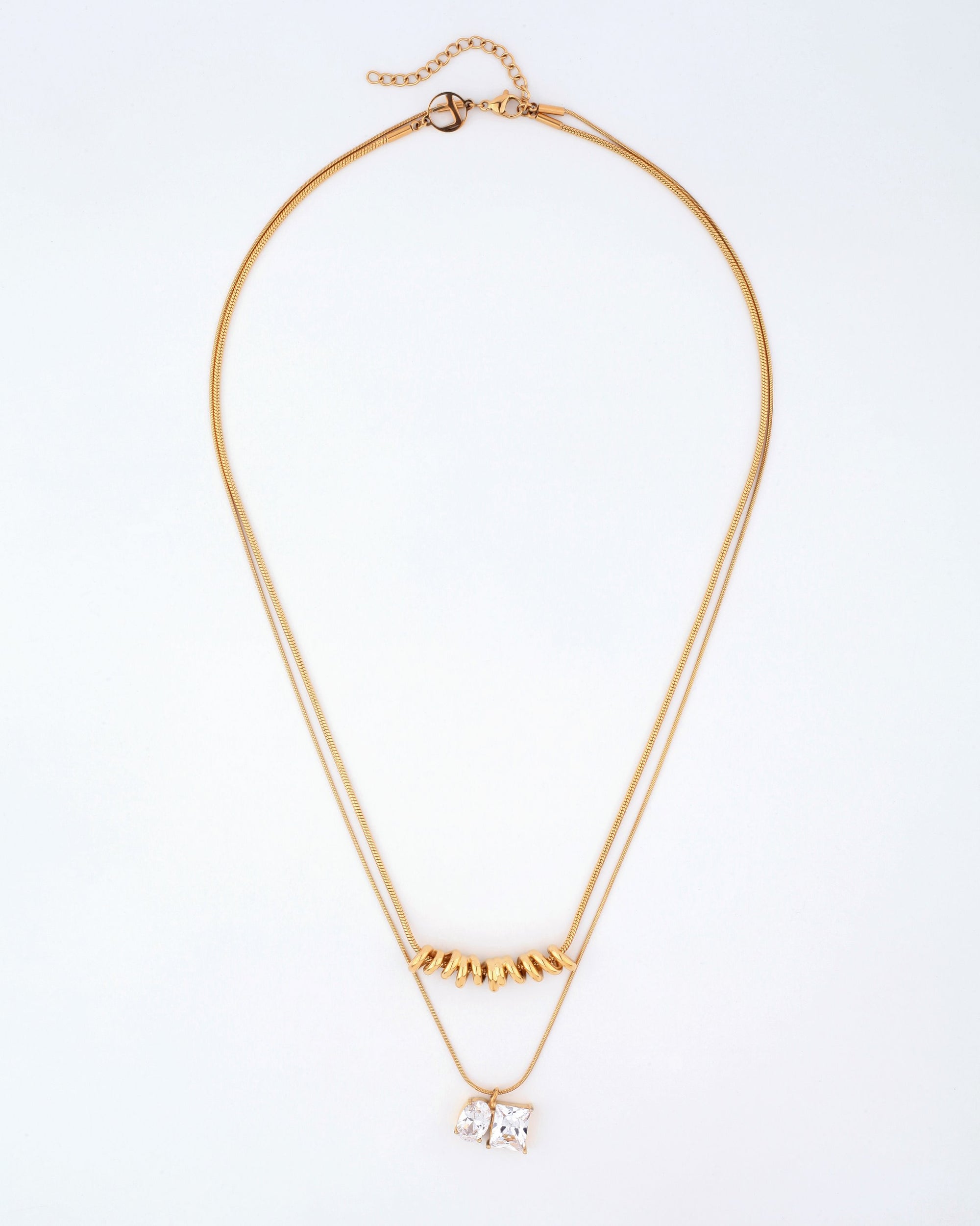 Introducing the Nora Necklace by For Art's Sake®: A delicate double-layered masterpiece showcased on a pristine white background. The upper layer is adorned with a row of dainty gold triangular charms, while the lower layer features a pendant with two square crystals set side by side. This elegant necklace boasts a thin gold chain complete with an adjustable clasp and extension chain for versatile length adjustments.