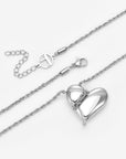 For Art's Sake® The Puffy Heart Pendant is a silver rope chain necklace with a shiny puffed heart charm partially wrapped by the chain, plus an adjustable extension and lobster clasp.