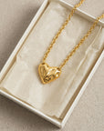 The Sculpted Heart Necklace by For Art's Sake® features an abstract, textured heart pendant on a delicate chain, presented in a white jewelry box with cream tissue. Perfect for everyday wear.
