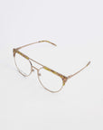 A pair of prescription eyeglasses featuring a gold metal frame with round lenses. The upper part of the frame has a subtle tortoiseshell pattern, while the temples are thin and uniformly gold. With UV protection, Frosty by For Art's Sake® stands out against the plain white background, highlighting their elegance.