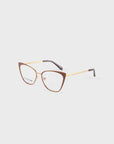 Discover the Stella Two by For Art's Sake®: cat-eye glasses with brown frames, gold metal arms with black tips, and clear lenses. Hand-painted enamel finish against a light gray backdrop adds unique flair to this optic style.