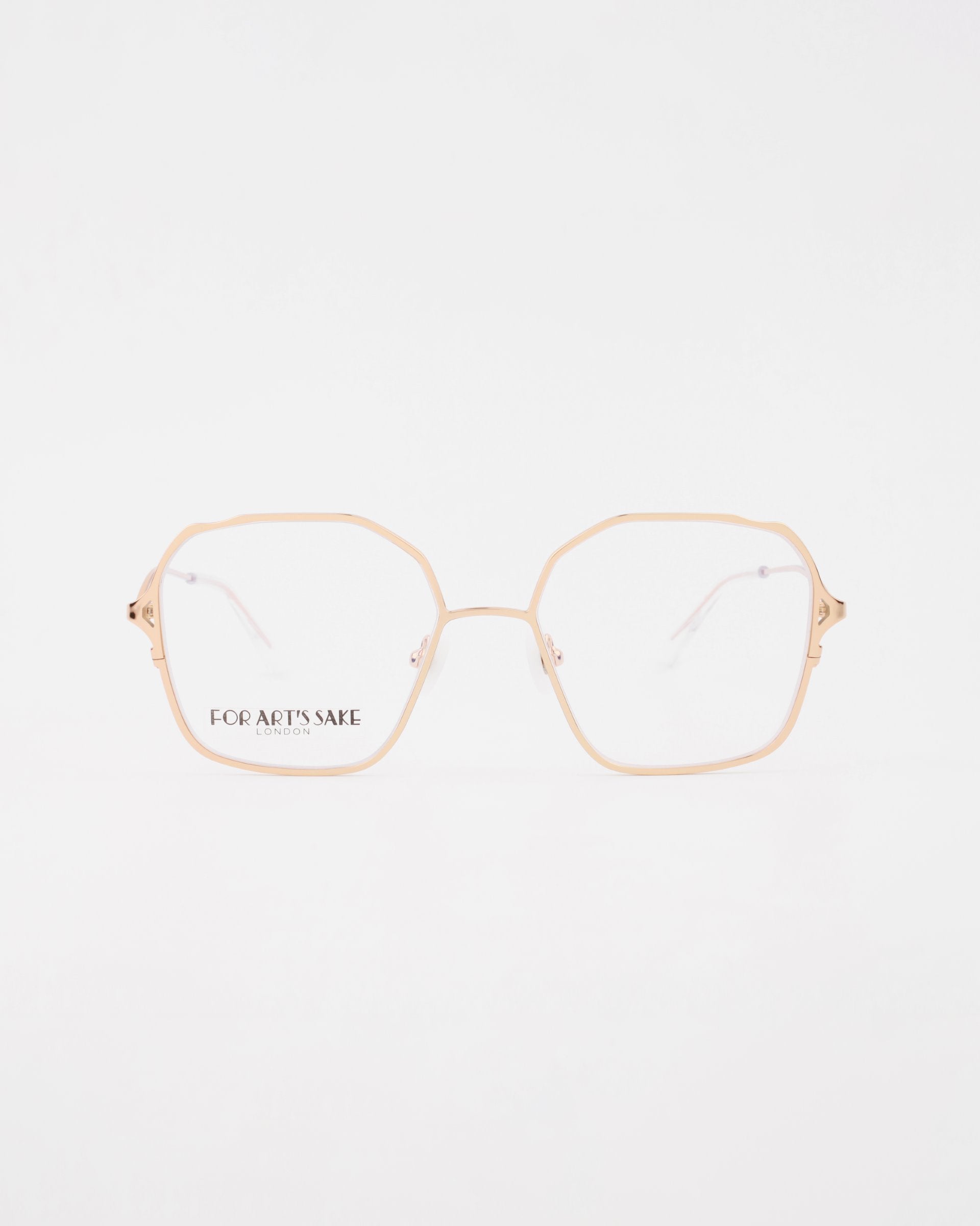 A pair of eyeglasses with thin, 18-karat gold-plated hexagonal frames featuring clear lenses. The brand name "For Art's Sake®" is printed in black on the left lens. These stylish Mimi glasses, available with a Blue Light Filter and Prescription Service, are set against a clean white background.