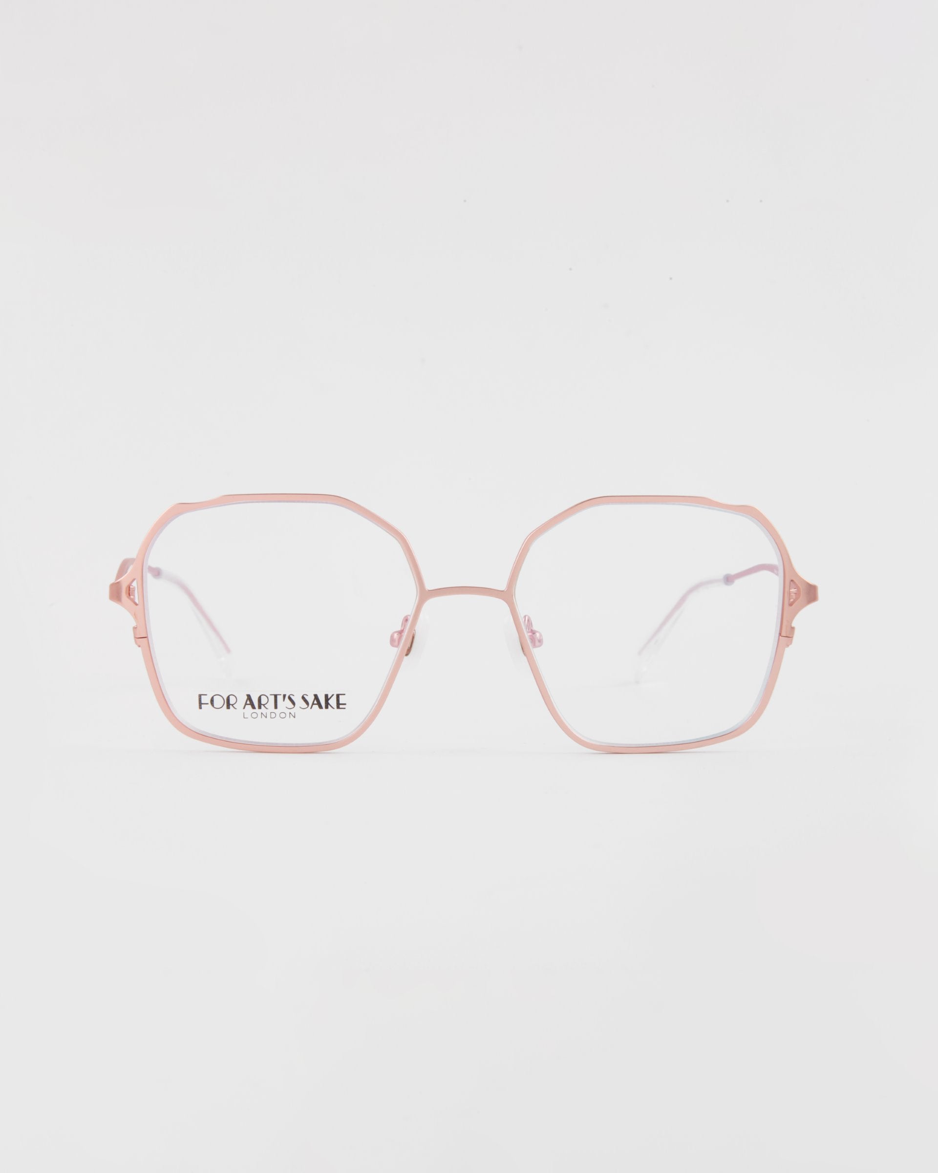 A pair of hexagon-shaped eyeglasses with a pink frame viewed from the front. The lenses are clear, showing the brand name "For Art's Sake®" on the left lens. They feature a blue light filter for added eye protection. The background is plain white. This is the Mimi from For Art's Sake®.