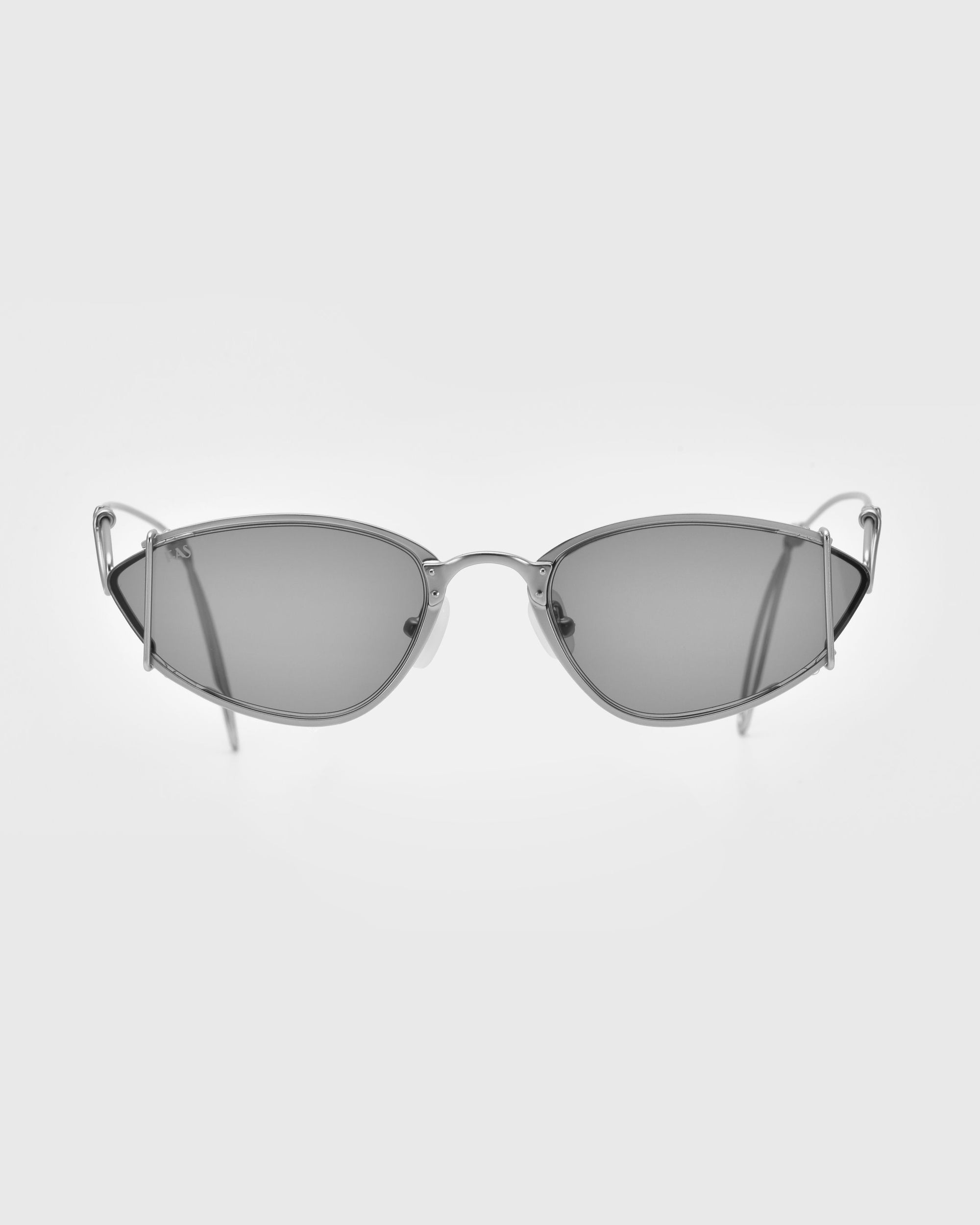 A pair of sleek, futuristic silver Ornate sunglasses with thin wire frames and dark lenses by For Art's Sake®. The design features a minimalist aesthetic with sharp, angular lines and curved temples. Offering UV protection, the background is plain white, highlighting the sunglasses.