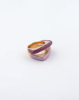 Introducing the For Art's Sake® Delta Ring, a modern accessory featuring intertwining bands of gold-tone metal and a glossy pink enamel finish, set against a plain white background. The layered design boasts contemporary aesthetics, making it perfect for lovers of minimalistic fashion.