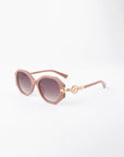 A pair of stylish round sunglasses with light pink, handmade acetate frames and gradient dark, shatter-resistant lenses. The arms feature gold-plated temple detailing near the hinges, adding a touch of elegance. The background is plain white, highlighting the Seaside by For Art's Sake®.