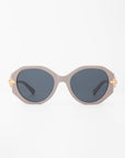 A pair of stylish Seaside sunglasses by For Art's Sake® with dark oval, shatter-resistant lenses and a light beige, handmade acetate frame. The temples feature gold-plated detailing near the hinges, adding a touch of elegance to the design. The background is solid white.