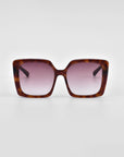 A pair of large, square-framed For Art's Sake® Eos sunglasses with a tortoiseshell pattern and gradient pink lenses is centered against a plain white background. Featuring an oversized soft-square silhouette, the For Art's Sake® Eos sunglasses have a modern, stylish design with wide arms.