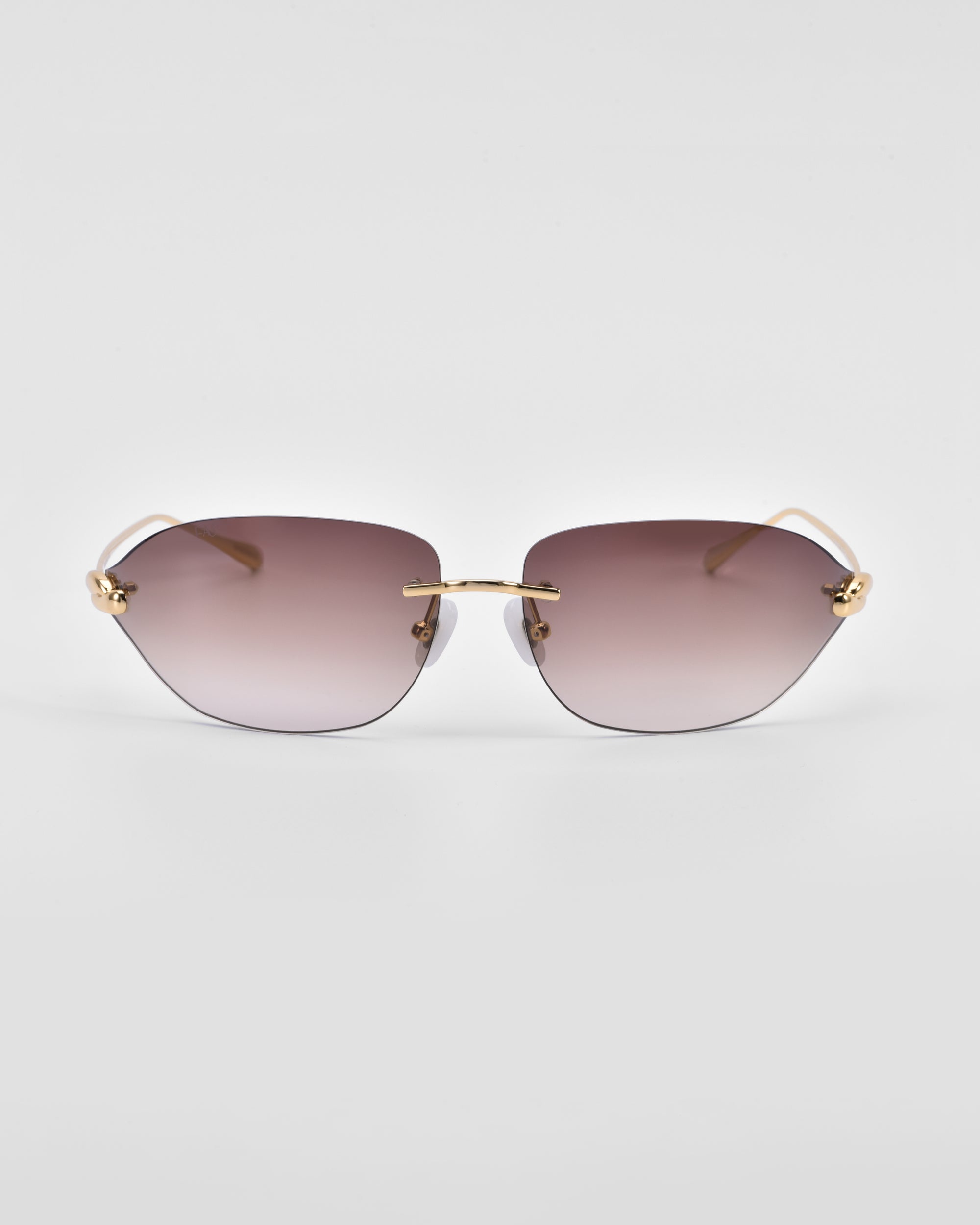 A pair of stylish Serpent I sunglasses by For Art's Sake® with a bold frameless wrap lens design and gradient lenses transitioning from dark purple at the top to lighter shades towards the bottom. The sunglasses feature natural jade-stone nose pads and 18-karat gold plating on the temples, set against a white background.