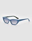 The Claude Monet by For Art's Sake® are blue cat-eye sunglasses with thick frames and tinted lenses, shown on a light gray background. This limited edition adds timeless style to any look.