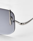 The Vermilion sunglasses by For Art's Sake® showcase a stylish metal frame and dark tinted lenses. Notable are the curved arms with dripping metal accents, highlighting their shiny finish against a plain background.