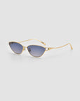 The Tulip II cat-eye sunglasses by For Art's Sake® feature gold frames, a bold acetate front, and blue gradient lenses, shown against a plain light gray background.