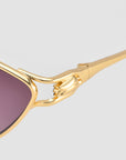 Close-up of For Art's Sake® Tulip II gold sunglasses, featuring a bold acetate front, sculpted hand temple detail gripping the frame, and purple-tinted lenses.
