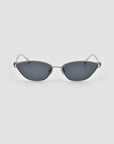 The Tulip II by For Art's Sake® features sculptural cat-eye sunglasses with silver metal frames and dark tinted lenses, showcased on a plain light gray background.