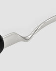 A close-up of the silver, zigzag-shaped arm of For Art's Sake® Abstraction I sculptural metal sunglasses set against a plain white background.