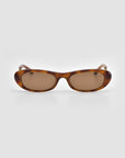 Abstraction I by For Art's Sake® are brown oval sunglasses with a tortoiseshell frame, dark brown lenses, and bold temples, shown on a light gray background.
