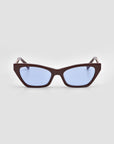 The Mesa II by For Art's Sake® are quiet luxury cat-eye sunglasses featuring thick, dark brown frames and light blue tinted lenses, shown against a plain light gray background.