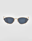 Introducing Ornate by For Art's Sake®: a pair of sleek, modern statement sunglasses featuring a slim, 18-karat gold-plated metal frame and dark lenses. The design includes slightly angled, cat-eye-shaped lenses and thin, curved temple arms. They offer 100% UVA & UVB protection and are displayed against a plain, light gray background.