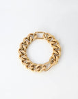 A chunky 18k gold-plated chain bracelet with large interlocking links, arranged in a circular shape, is displayed on a plain white background. The Wave Bracelet Gold by For Art's Sake®, echoing the bold style of 80s jewellery, has a clasp visible at the top.
