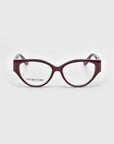 Close-up of Rosalia I eyeglasses by For Art's Sake® with dark red, oversized, rounded square frames from the Rose Garden Collection. Clear lenses reveal "FOR ART'S SAKE" on the left lens. The plain light gray background highlights their femininity and elegance.