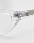 Close-up of the Rosalia II cat-eye optical frame by For Art's Sake® from the Rose Garden Collection. The clear frames exude femininity, featuring a silver temple arm with textured finish and circular detail, elegantly displayed against a soft white background.